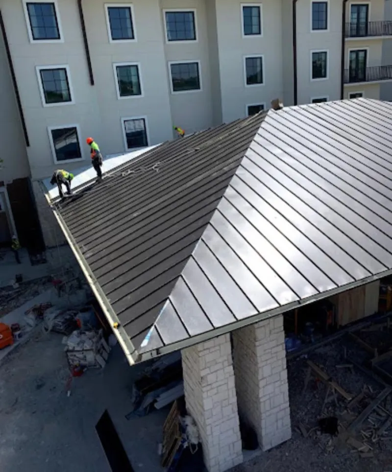 Crew installing standing seam metal roof panels on a commercial project in San Pablo